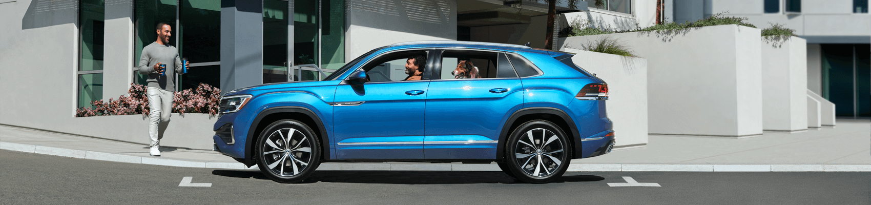 Volkswagen SUV parked on street next to coffee shop